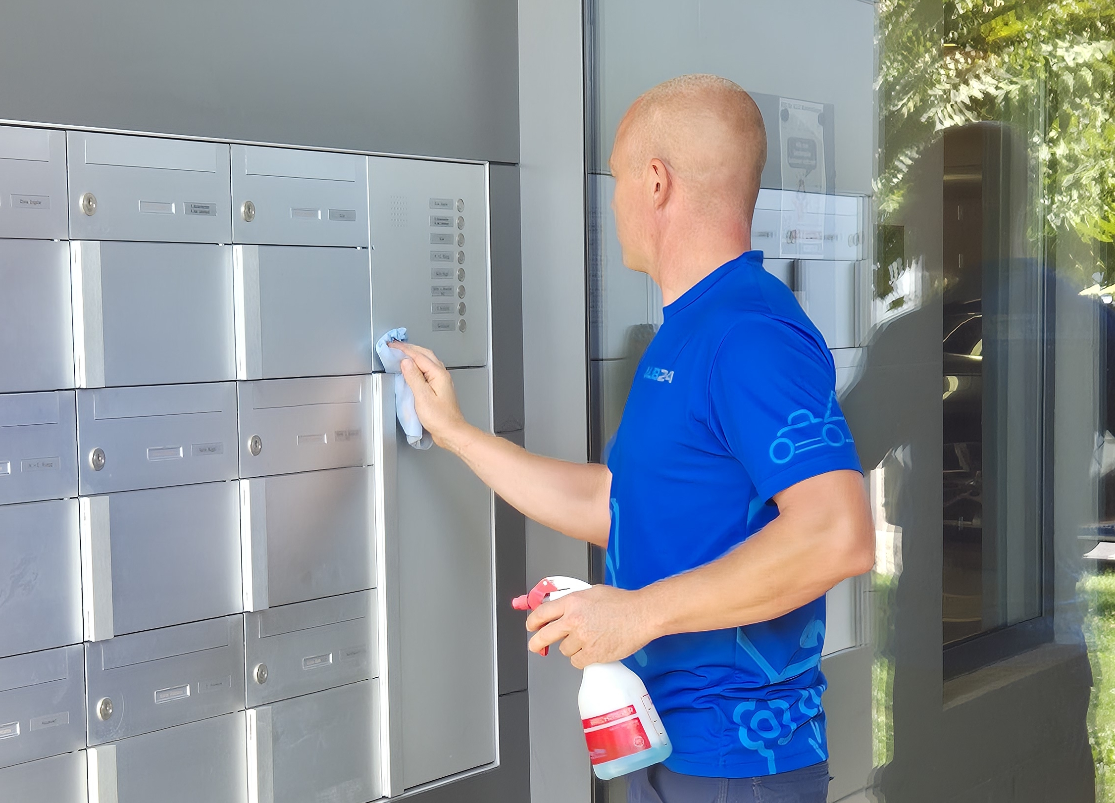 Mitarbeiter der ALB24 GmbH reinigt die Briefkastenanlage beim Hauseingang