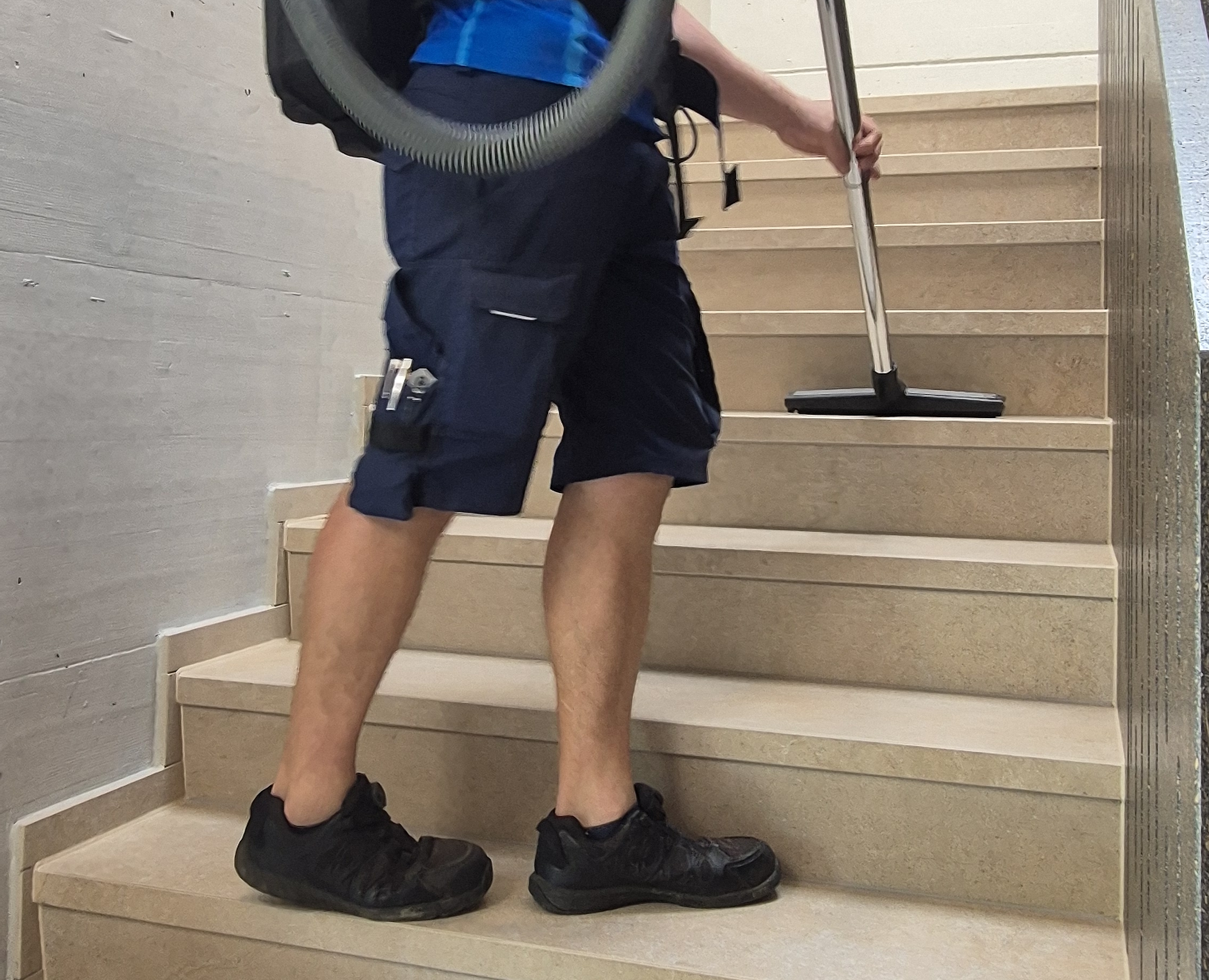 Treppenhaus wird mit dem Rückensauger Stufe für Stufe gesaugt